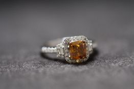 AN 18ct WHITE GOLD FANCY BROWN CUSHION CUT DIAMOND RING, with diamond halo and shoulders. Fancy