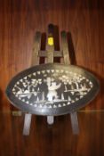 A SMALL WOODEN EASEL HOLDING A MOTHER OF PEARL INLAID WOODEN OVAL PLAQUE