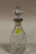 A SMALL CUT GLASS HALLMARKED SILVER COLLARED DECANTER