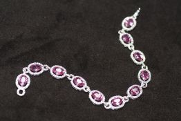AN 18ct WHITE GOLD PINK SAPPHIRE AND DIAMOND OVAL LINE BRACELET, boxed. Pink sapphires 10.15ct.