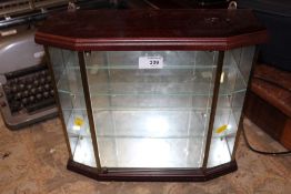 A SMALL MIRRORED GLASS DISPLAY UNIT