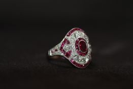 AN ORNATE PLATINUM RUBY AND DIAMOND DRESS RING, Set with an oval-cut ruby, calibre-cut rubies and