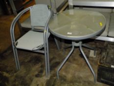 A CIRCULAR GLASS TOPPED TABLE & TWO CHAIRS