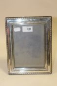 A HALLMARKED SILVER PHOTO FRAME OVERALL SIZE - 23 X 18 CM