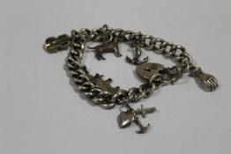 AN ANTIQUE SILVER CHARM BRACELET
