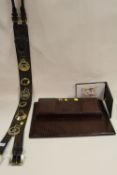 A LONG LEATHER MARTINGALE OF HORSE BRASSES AND A SNAKESKIN EFFECT DESK TIDY, FOLDER AND ANOTHER (4)