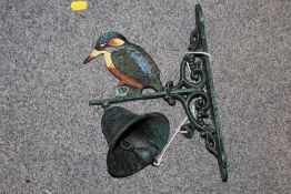 A CAST METAL WALL HANGING BELL WITH KINGFISHER FINIAL