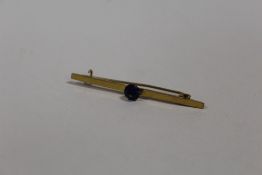 A 9 CT GOLD BAR BROOCH SET WITH A BLUE STONE
