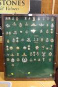 AN OAK DISPLAY CASE CONTAINING A DISPLAY OF VINTAGE MILITARY BADGES AND BUTTONS ETC.