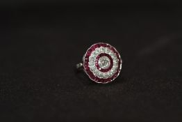 A PLATINUM RUBY AND DIAMOND RING, set with a central old-cut diamond, surrounded by a halo of