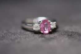 AN 18ct WHITE GOLD PINK SAPPHIRE AND DIAMOND THREE STONE RING, Oval-cut pink sapphire 1.50ct. RBC
