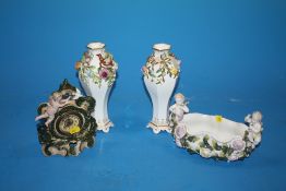 A PAIR OF CONTINENTAL CERAMIC FLORAL VASES TOGETHER WITH A CHERUBIC CLOCK WITH CROSSED SWORDS BACK