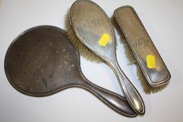 A HALLMARKED SILVER THREE PIECE BRUSH AND MIRROR SET