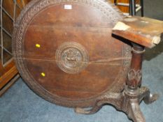 AN ANTIQUE CARVED OAK TILT-TOP PEDESTAL TABLE - DAMAGE TO THE TOP OF THE PEDESTAL