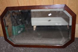 AN OAK FRAMED OCTAGONAL BEVEL EDGED WALL MIRROR