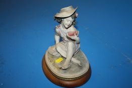 A SIGNED CAPE DI MONTE FIGURE OF A GIRL EATING A WATERMELON