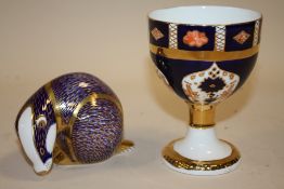 A ROYAL CROWN DERBY BADGER PAPER WEIGHT, TOGETHER WITH A ROYAL CROWN DERBY STYLE CHALICE SIGNED M.