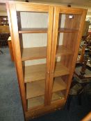A MODERN PINE GLAZED FLOORSTANDING BOOKCASE WITH TWO DRAWERS H-183 W-80 CM