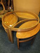 A RETRO GLASS TOPPED TEAK COFFEE/NEST OF TABLES WITH 3 'EYE' SHAPED NESTS H-51 DIA 81 CM WITH A