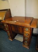 A MAHOGANY CASED SINGER TREADLE SEWING MACHINE WITH SEWING ACCESSORIES IN THE DRAWERS