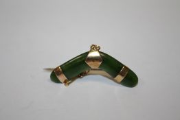 A 9CT ROSE GOLD MOUNTED JADE BROOCH IN THE FORM OF A BOOMERANG