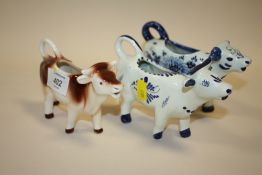 THREE CERAMIC COW CREAM JUGS TO INCLUDE A GOEBEL EXAMPLE
