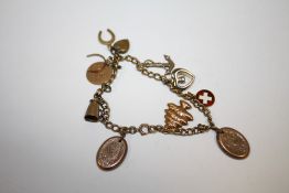 A VINTAGE CHARM BRACELET WITH 9 CARAT GOLD AND YELLOW METAL CHARMS