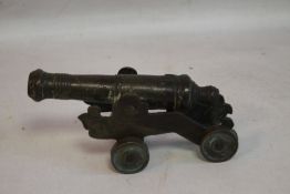 A SMALL ANTIQUE SIGNAL CANNON ON SHEET METAL CARRIAGE