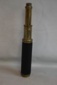 AN ANTIQUE BRASS & LEATHER THREE DRAW TELESCOPE, signed 