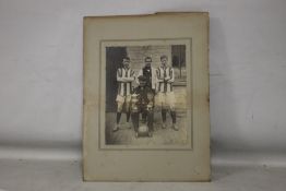 W.U.F.C. 1911-12, a photograph of four men with two trophies and a football, two in sports strip and