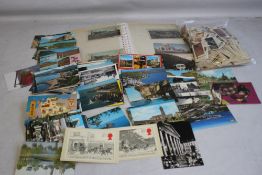 AN ALBUM OF POSTCARDS, along with a tin of loose cards and a selection of tea cards.