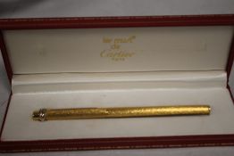A CARTIER GOLD PLATED BALL POINT PEN IN FITTED BOX, with guarantee card and outer card slip box