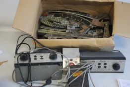 A BOX OF DUBLO THREE RAIL TRACK AND BOX TRANSFORMER.