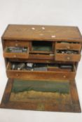 A VINTAGE WOODEN ENGINEERS TOOL CHEST FITTED WITH 8 DRAWERS AND A LIFT OFF FRONT PANEL, with a