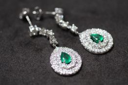 A PAIR OF 18ct WHITE GOLD PEAR DROP EMERALD AND DIAMOND CLUSTER DROP EARRINGS, boxed. Emeralds 1.