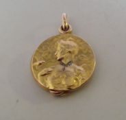 AN ART NOUVEAU DIAMOND SET YELLOW METAL PENDANT LOCKET, depicting a maiden with a bird in relief,