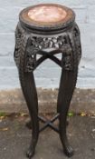 AN ORIENTAL CARVED HARDWOOD JARDINIERE STAND, with circular inset marble panel, H 92.5 cm