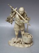 A JAPANESE IVORY OKIMONO, depicting a fruit seller holding a rod over his shoulder with his