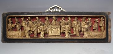 AN ORIENTAL CARVED AND GILT WOOD RECTANGULAR PANEL, modelled as figures carved in relief around a