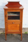 AN EDWARDIAN MAHOGANY INLAID MUSIC CABINET, having a small glazed door above a pull-out panelled