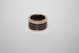 A BVLGARI 18CT ROSE GOLD FOUR BAND RING, the ring with black sprung ceramic spiral design to the