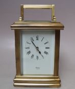 A BRASS CASED CARRIAGE CLOCK BY HUBER OF LONDON, white enamel dial with Roman numerals, movement