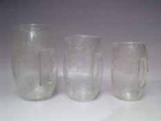 A SET OF THREE GRADUATED CRACKLE GLASS JUGS DESIGNED BY KOLOMON MOSER FOR LOETZ, of barrel form with