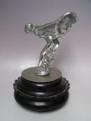 A VINTAGE CHROMED STATUETTE / CAR MASCOT OF 'THE SPIRIT OF ECSTASY', raised on a circular base,