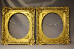 A PAIR OF MID 19TH CENTURY DECORATIVE GILT FRAMES WITH CORNER EMBELLISHMENTS AND OVAL SPANDRELS,