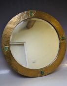 AN EARLY 20TH CENTURY ARTS AND CRAFTS CIRCULAR COPPER WALL MIRROR WITH FOUR OVAL GREEN STONE