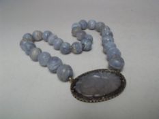 A LAVENDER JADE CARVED PANEL AND BEAD NECKLACE, the individual beads approx Dia. 1.5 cm with