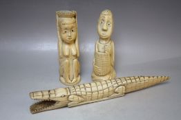 A PAIR OF EARLY 20TH CENTURY CARVED IVORY TRIBAL HEADS, together with an ivory carved crocodile, L