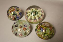 FOUR ASSORTED GLASS PAPERWEIGHTS TO INCLUDE MILLEFIORI CANE EXAMPLES, largest Dia 7 cm