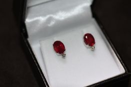 A PAIR OF 18ct WHITE GOLD RUBY AND DIAMOND STUDS, boxed. Rubies 4.00ct. Diamonds 0.06ct